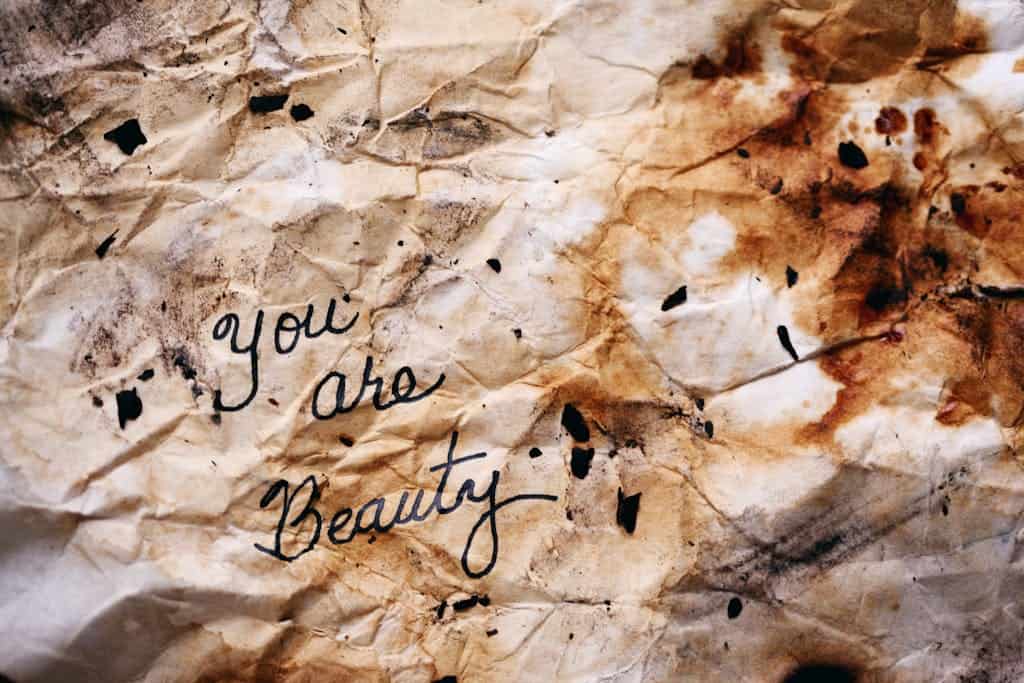 Crumpled burnt paper with artistic handwriting, capturing rustic beauty.