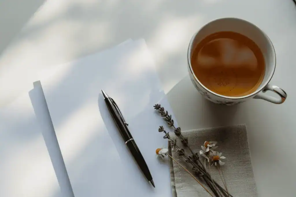 Cozy journaling setup with tea and blank paper, perfect for reflecting on birth chart insights and life purpose astrology revelations.